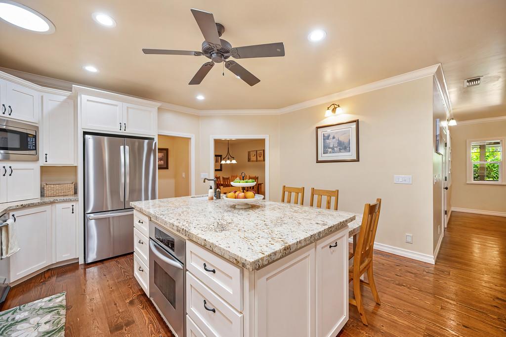 3557 Val Verde Road Loomis, CA 95650 - Photo 16 of 71 a kitchen with stainless steel appliances granite countertop a table chairs refrigerator and wooden floors