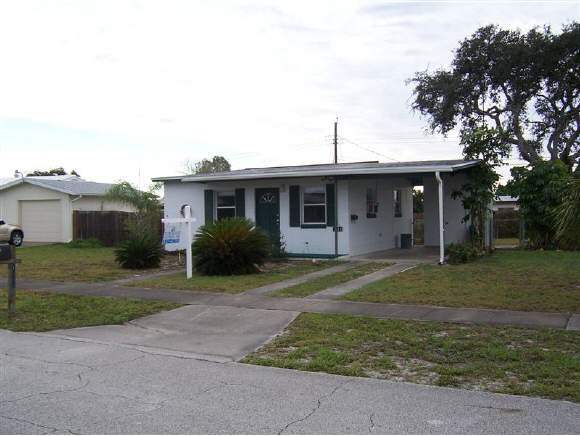 1042 Northeast Cable Palm Bay, FL 32905 - Photo 1 of 6 a front view of a house with a yard and trees