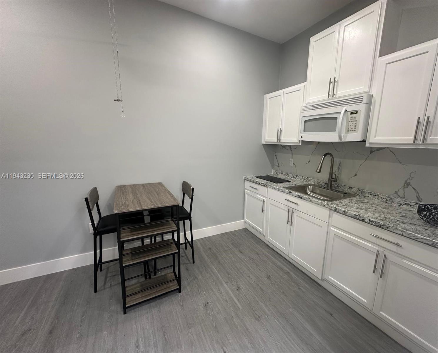 11879 Southwest 253rd Terrace Homestead, FL 33032 - Photo 15 of 15 a kitchen with granite countertop a sink cabinets and wooden floor