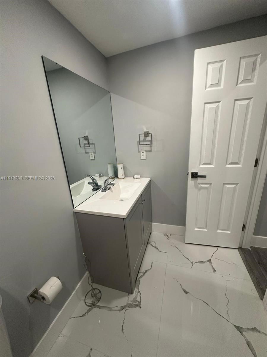 11879 Southwest 253rd Terrace Homestead, FL 33032 - Photo 3 of 15 a bathroom with a sink a mirror and a toilet