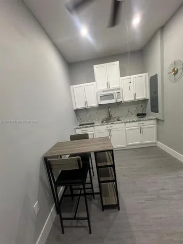 a kitchen with granite countertop a sink stove and cabinets