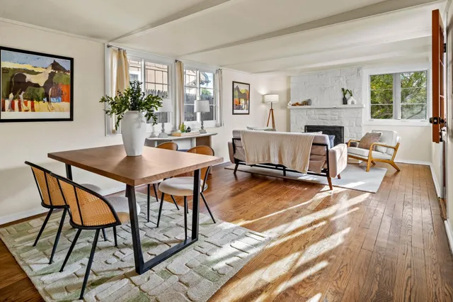a dining room with furniture window and wooden floor