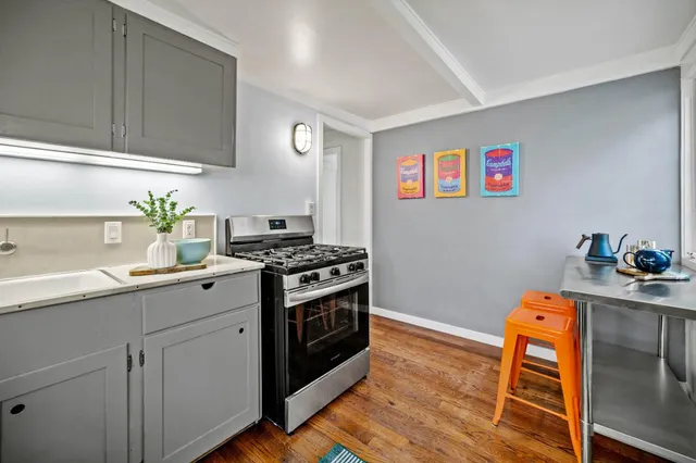 a kitchen with stainless steel appliances granite countertop a stove a sink and a microwave