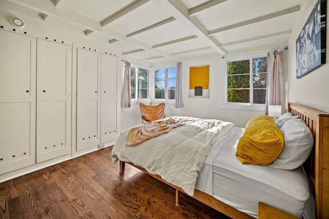 a bed sitting in a spacious bedroom next to a window