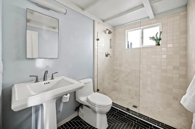 a bathroom with a sink toilet and shower