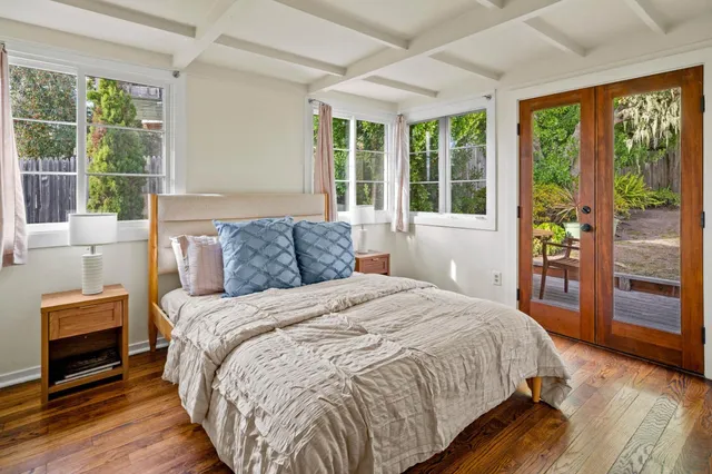 a spacious bedroom with a bed and wooden floor