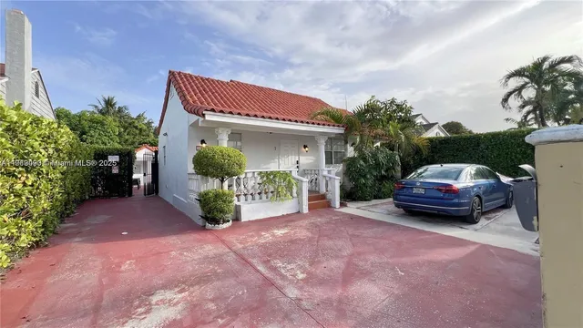 a yellow house with a cars parked in front of it