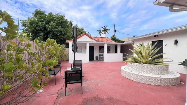 a view of a house with a yard potted plants