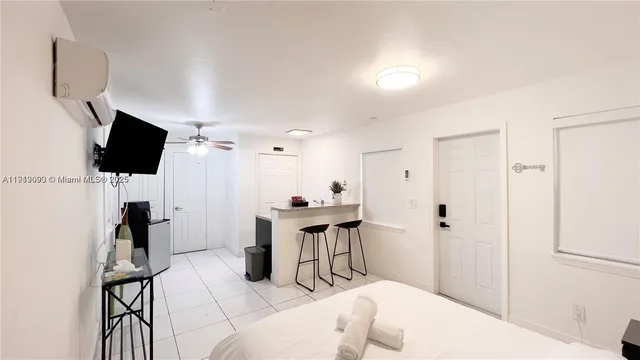 a living room with furniture a flat screen tv and a view of kitchen