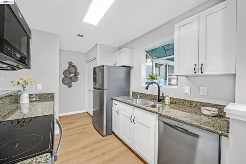 a kitchen with stainless steel appliances granite countertop a refrigerator sink and stove