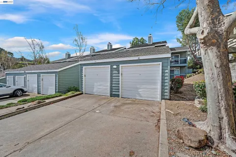 a view of garage with a car parked in front of it