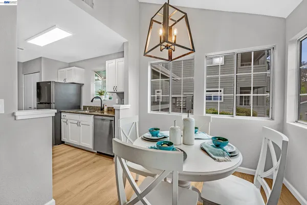 a kitchen with granite countertop stainless steel appliances a dining table and chairs
