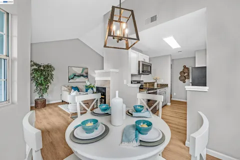 a view of a dining room with furniture a chandelier and wooden floor