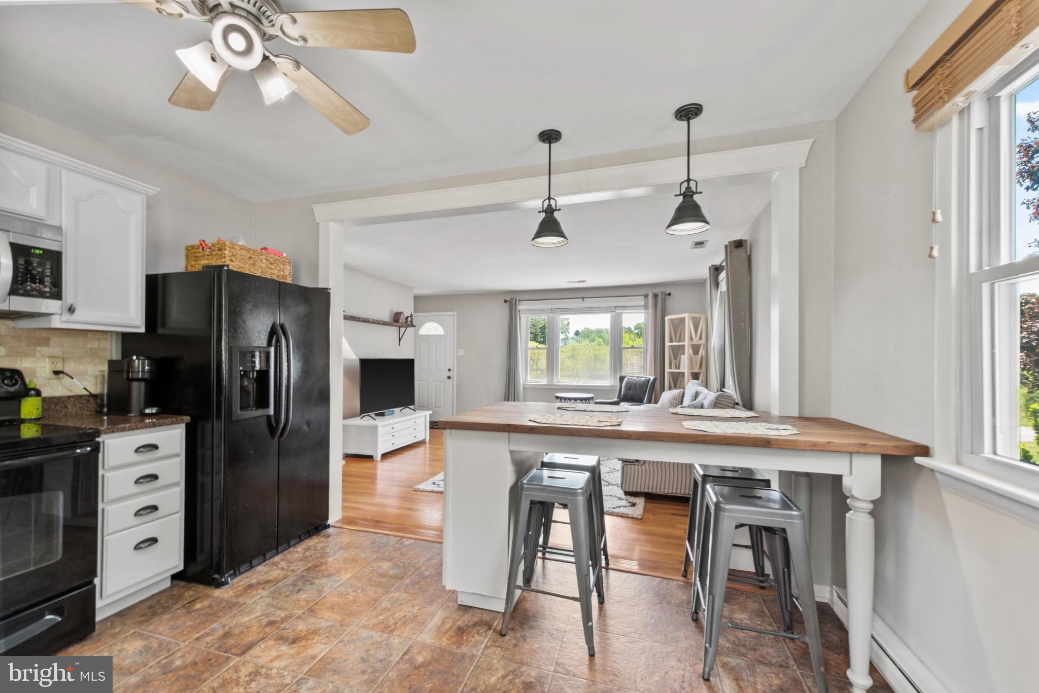 3242 Lineboro Road Manchester, MD 21102 - Photo 12 of 30 a kitchen with stainless steel appliances granite countertop a refrigerator a sink dishwasher a stove and a dining table with wooden floor