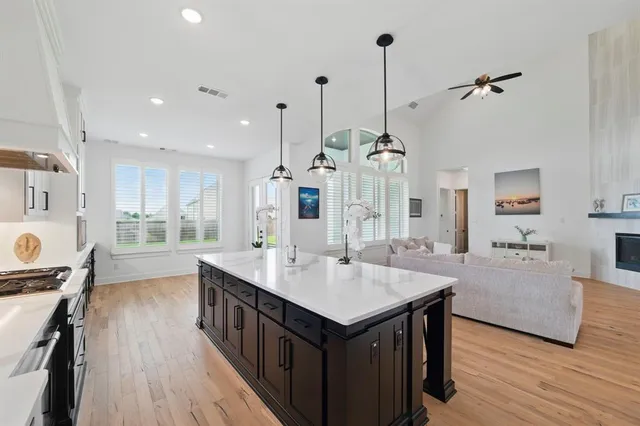 a open kitchen with kitchen island a wooden floor center island and stainless steel appliances