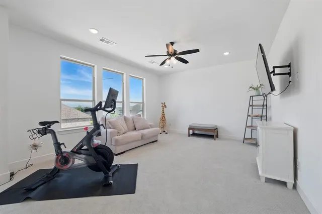 a living room with furniture and a ceiling fan