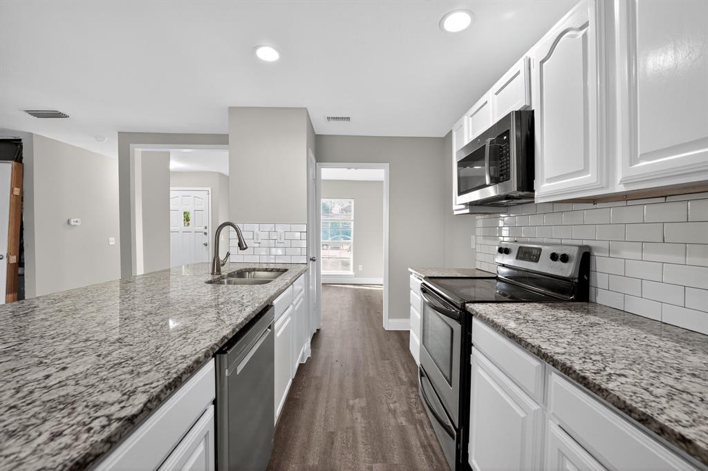 3601 Blue Ridge Lane Garland, TX 75042 - Photo 1 of 1 Kitchen with stainless steel appliances, light stone countertops, dark wood-style flooring, white cabinetry, and recessed lighting