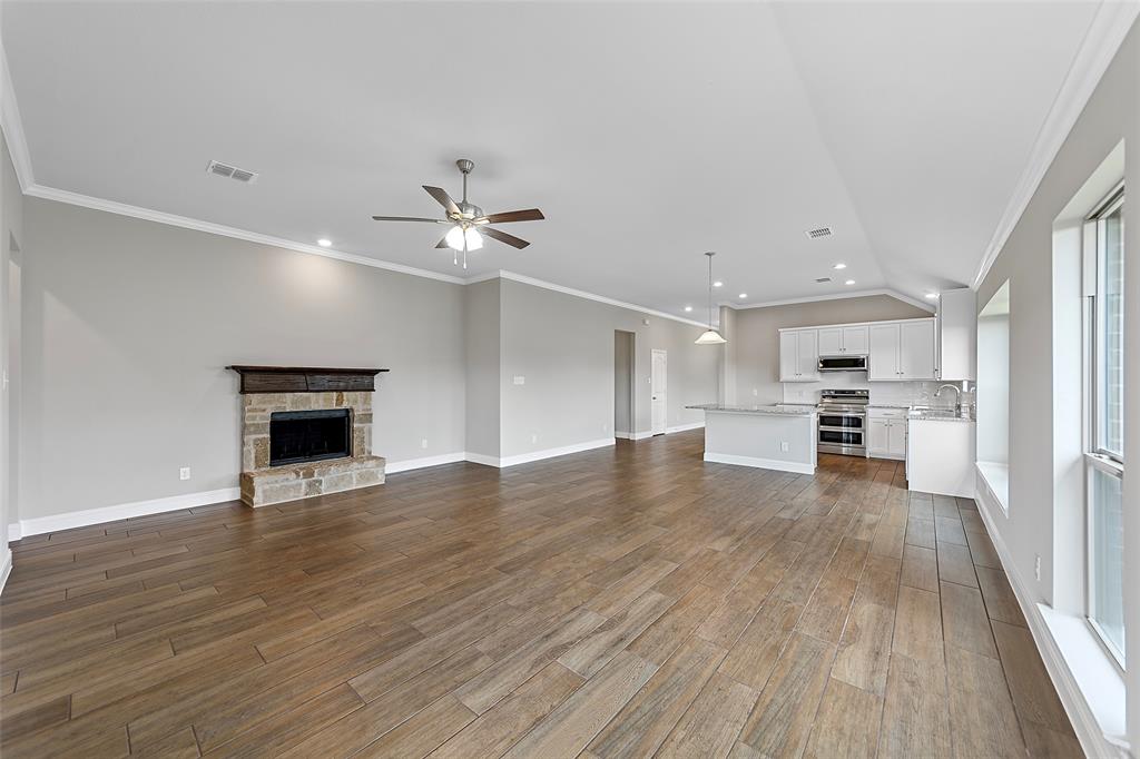 312 Pennington Road Josephine, TX 75173 - Photo 11 of 22 a view of an empty room with wooden floor a ceiling fan and windows