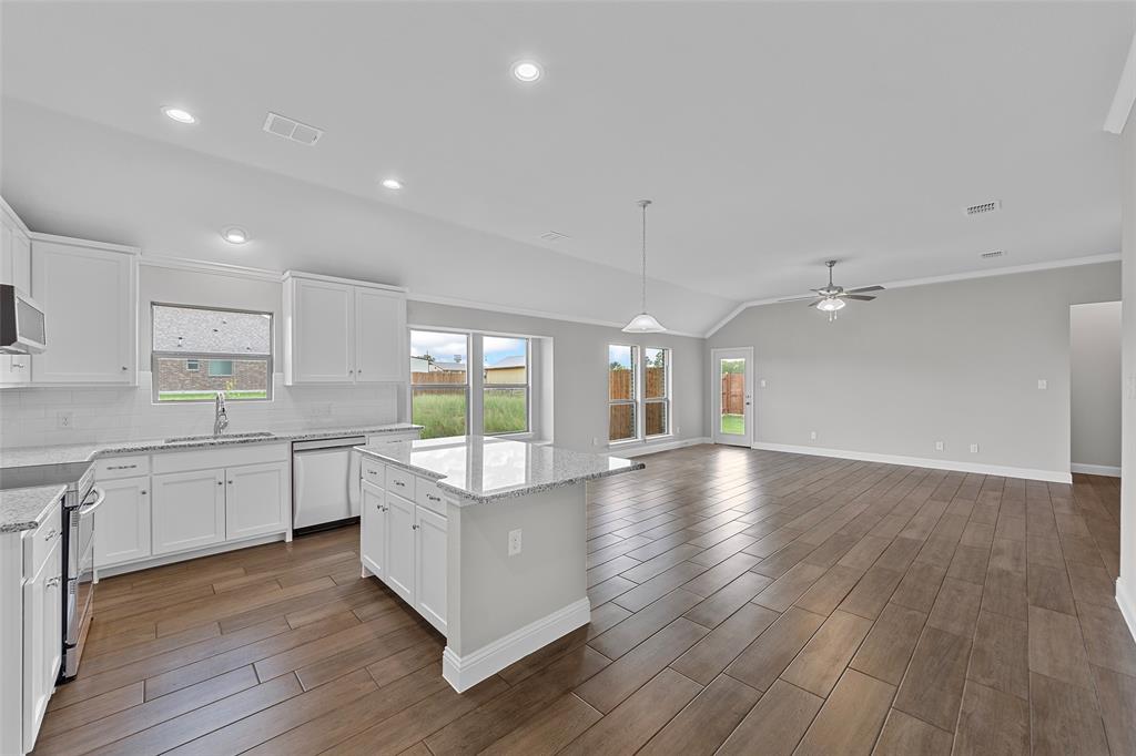 312 Pennington Road Josephine, TX 75173 - Photo 6 of 22 a large kitchen with lot of wooden floors and stainless steel appliances