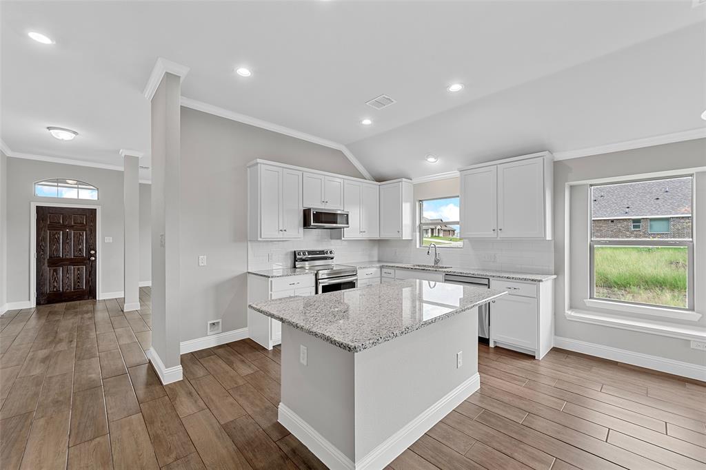 312 Pennington Road Josephine, TX 75173 - Photo 7 of 22 a large kitchen with stainless steel appliances granite countertop a lot of counter space and wooden floor