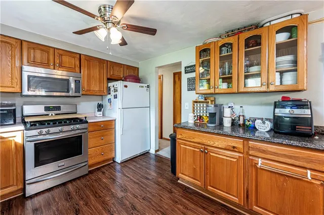 a kitchen with stainless steel appliances granite countertop a refrigerator a stove and a sink