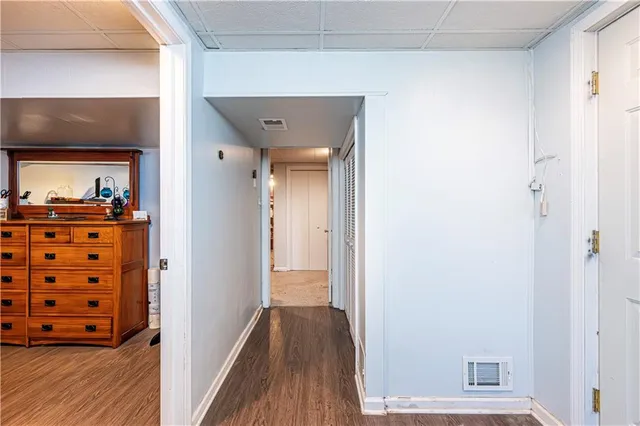 a view of a hallway with wooden floor and closet