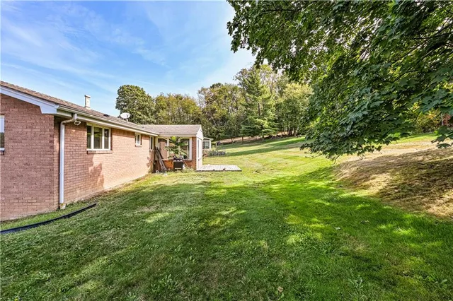 a view of a house with a backyard and a tree
