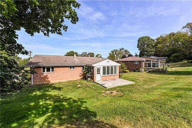 a front view of a house with a yard and trees