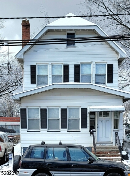 a front view of a house with car parked