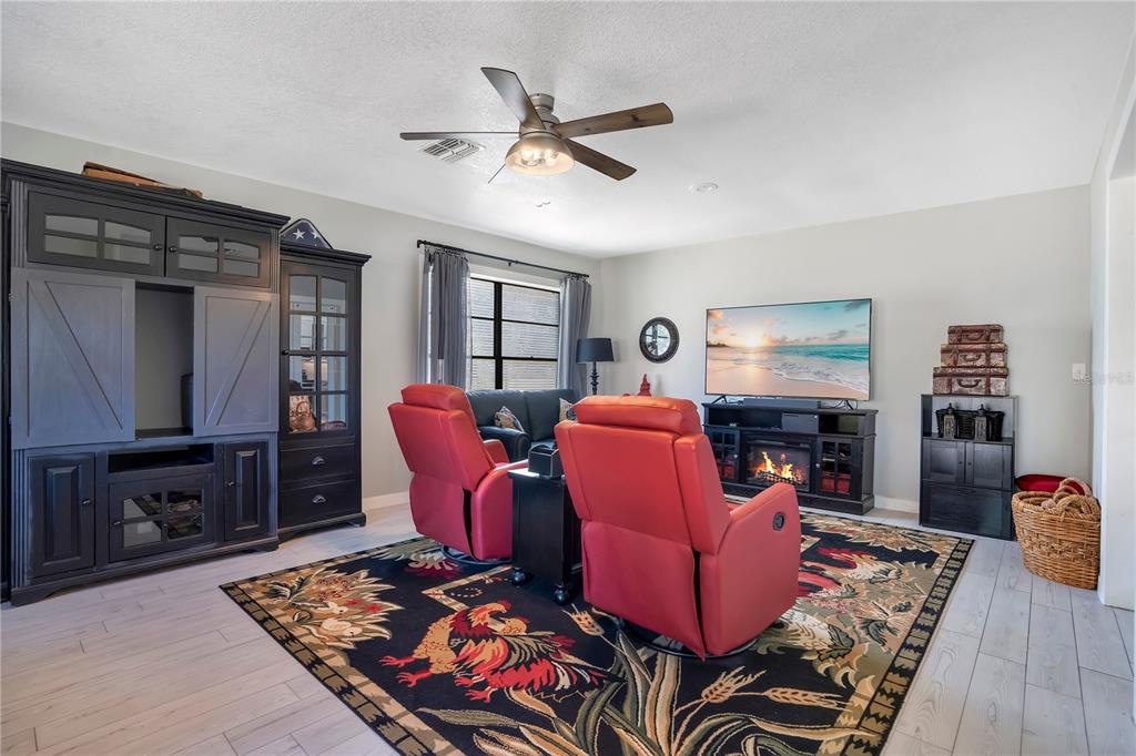8431 Delaware Drive Weeki Wachee, FL 34607 - Photo 30 of 64 a living room with furniture a ceiling fan and a rug