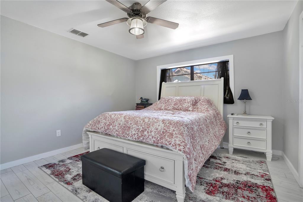 8431 Delaware Drive Weeki Wachee, FL 34607 - Photo 34 of 64 a bedroom with a bed and a chandelier