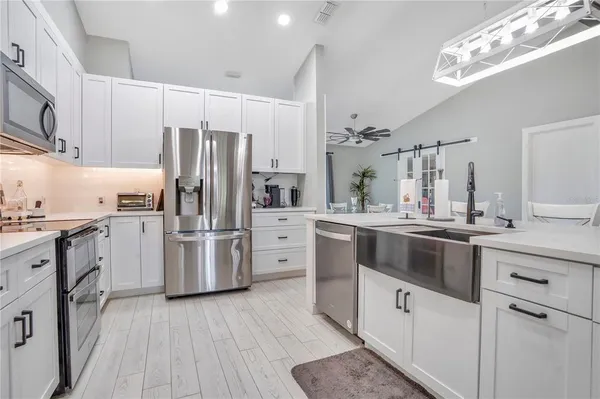 a kitchen with kitchen island granite countertop a sink cabinets and stainless steel appliances