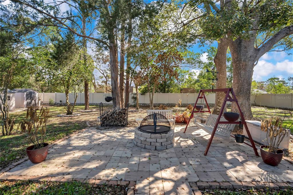 8431 Delaware Drive Weeki Wachee, FL 34607 - Photo 41 of 64 a view of a patio with table and chairs potted plants and large tree