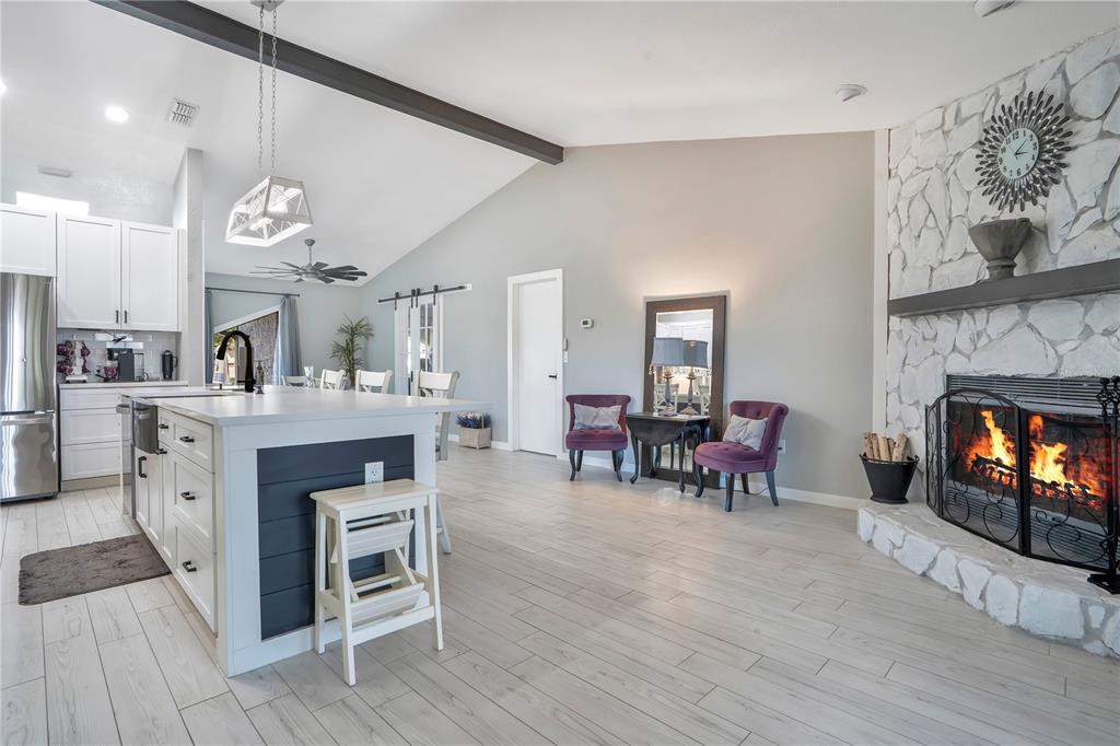 8431 Delaware Drive Weeki Wachee, FL 34607 - Photo 6 of 64 a large kitchen with a table chairs and a fireplace