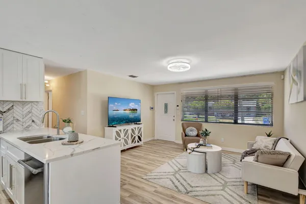 a living room with furniture a flat screen tv and a large window