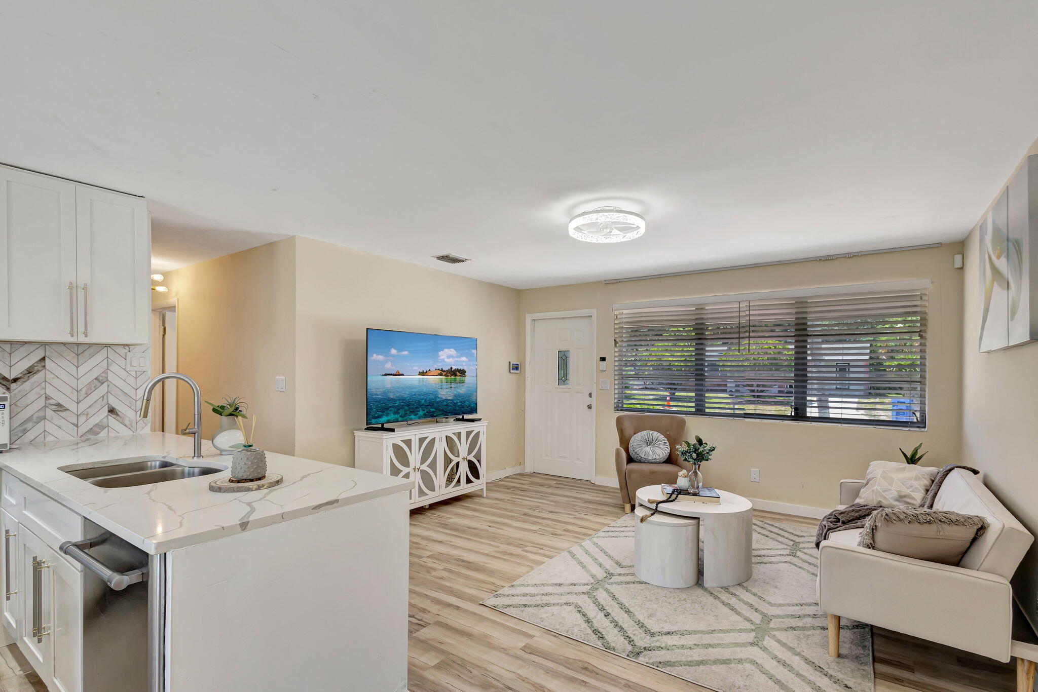 140 West 31st Court Riviera Beach, FL 33404 - Photo 15 of 43 a living room with furniture a flat screen tv and a large window