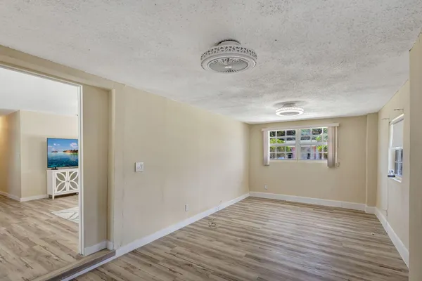 a view of an empty room with wooden floor