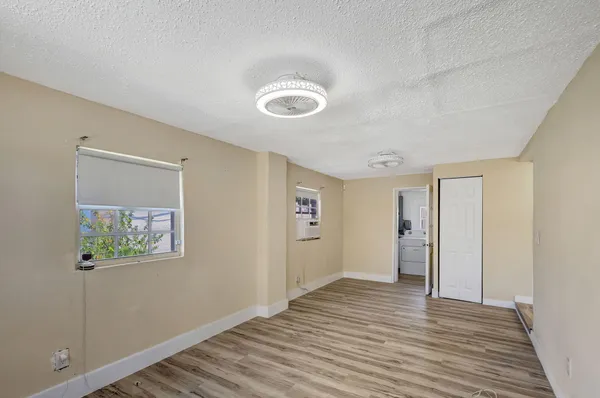 a view of a room with wooden floor and hallway