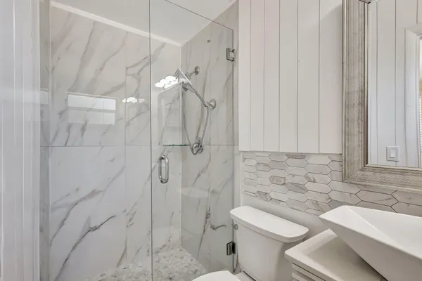a bathroom with a sink a toilet and shower