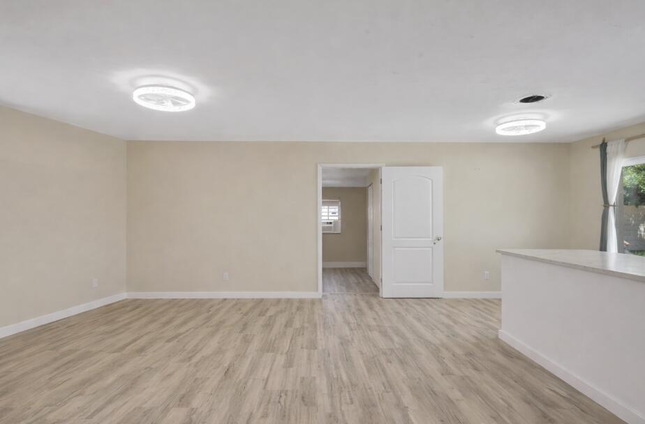 140 West 31st Court Riviera Beach, FL 33404 - Photo 3 of 43 wooden floor in an empty room with a window