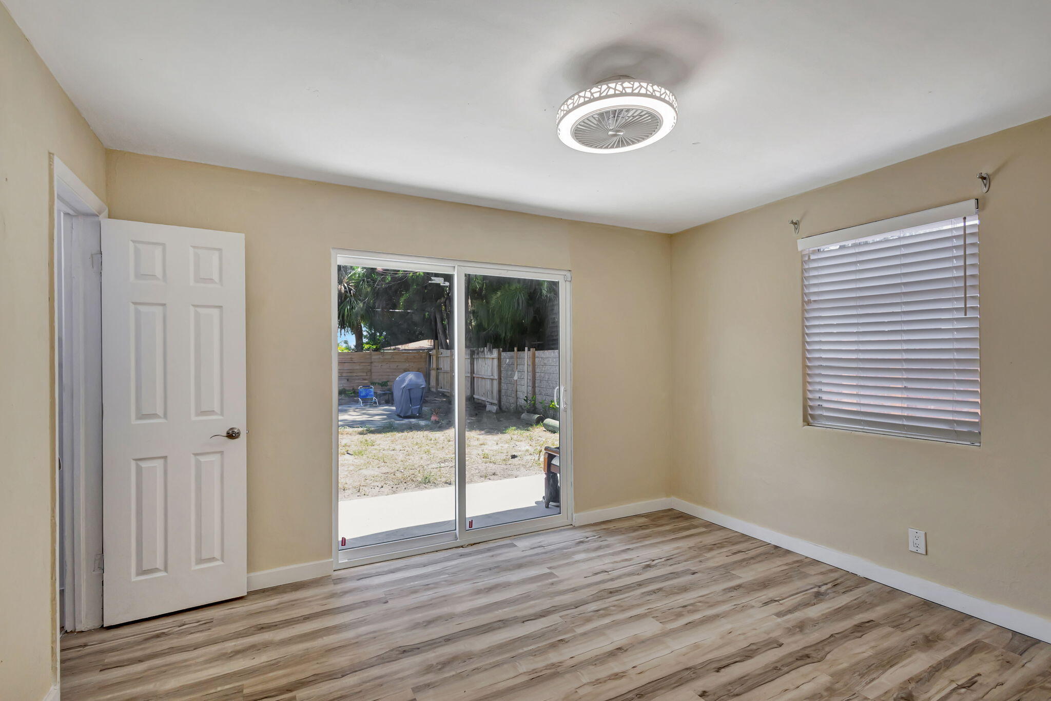 140 West 31st Court Riviera Beach, FL 33404 - Photo 33 of 43 a view of an empty room with wooden floor and a window