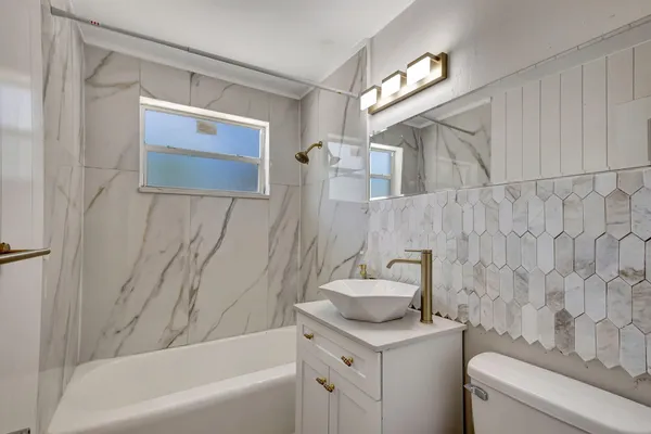 a bathroom with a sink a toilet and bathtub