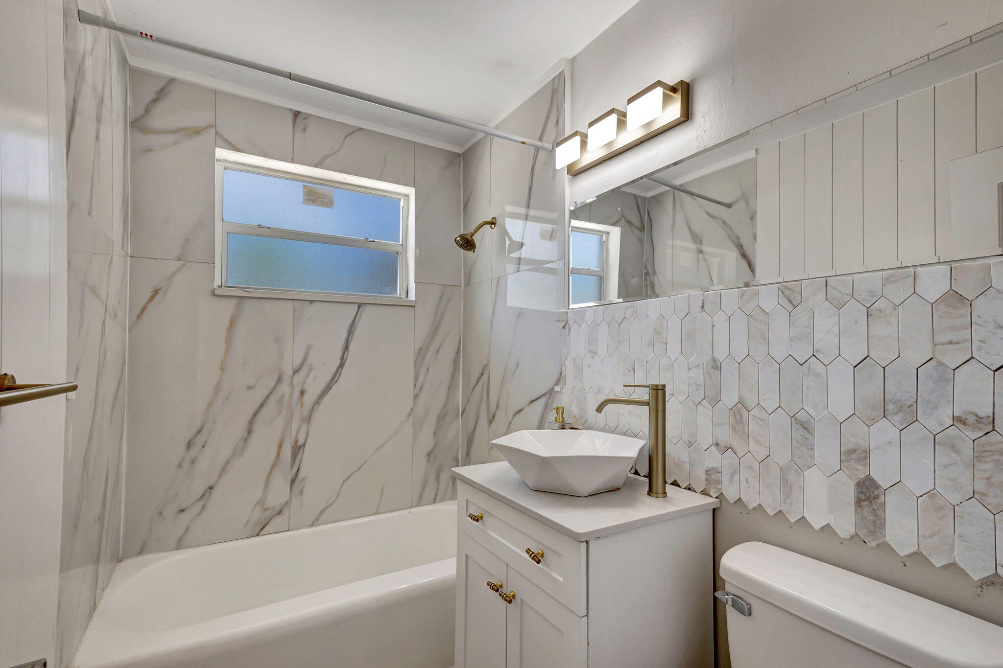 140 West 31st Court Riviera Beach, FL 33404 - Photo 38 of 43 a bathroom with a sink a toilet and bathtub