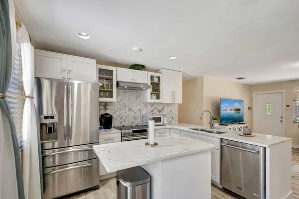 a kitchen with stainless steel appliances a refrigerator sink and stove