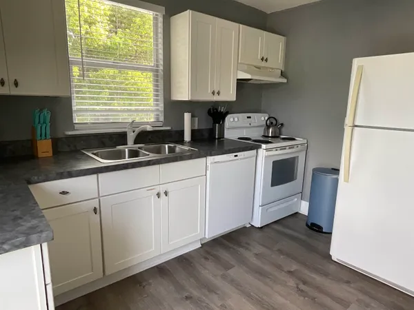 a kitchen with granite countertop white cabinets and white appliances