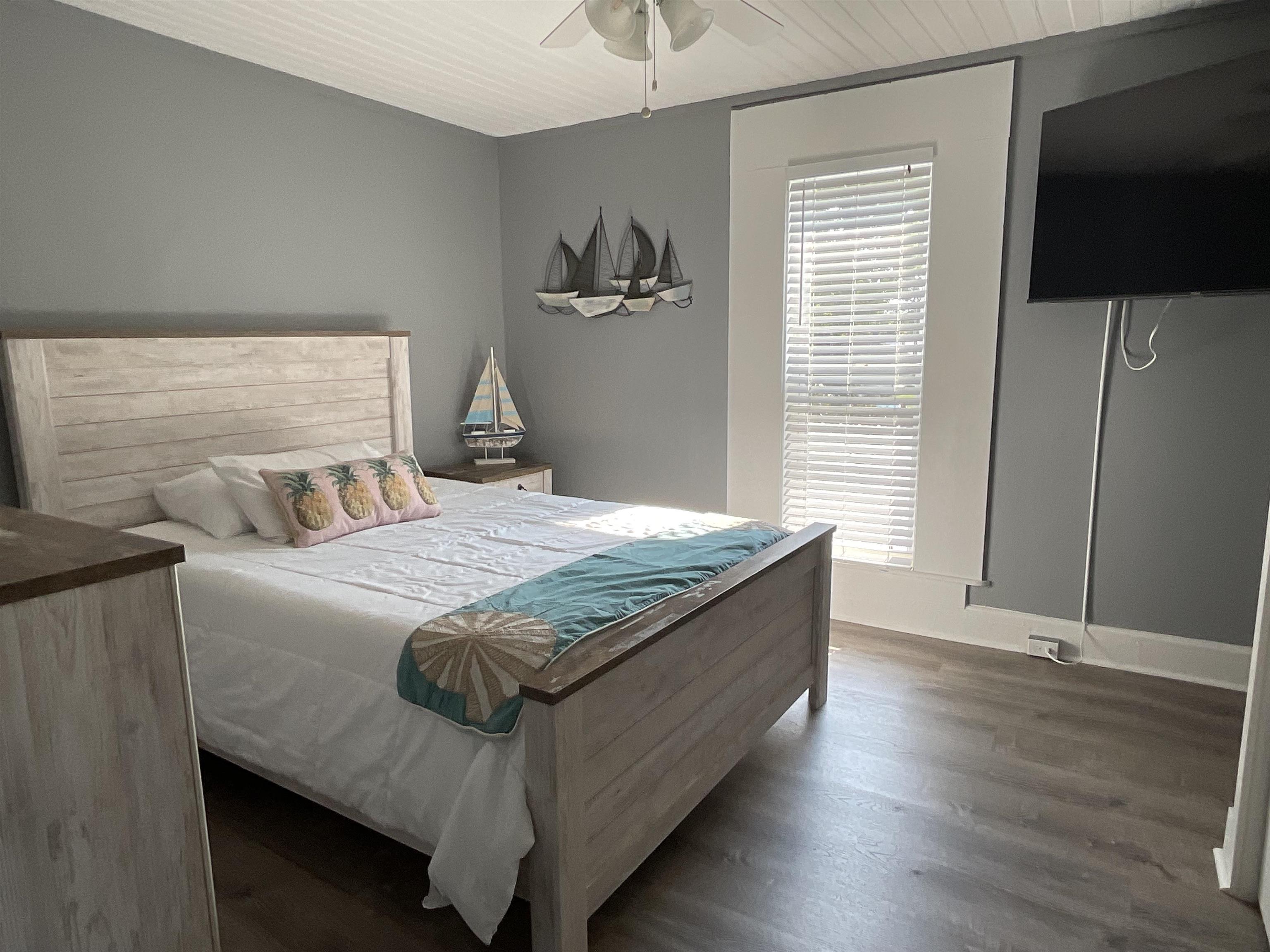 93 Keith Street, Unit B St. Augustine, FL 32084 - Photo 6 of 14 a bedroom with a bed and a flat screen tv