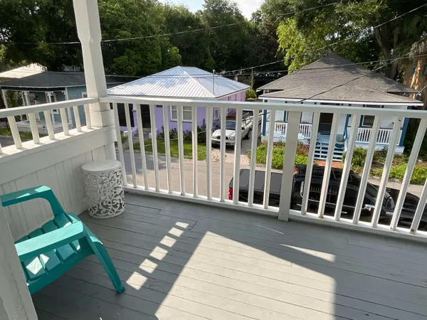 a view of a house with wooden deck and furniture