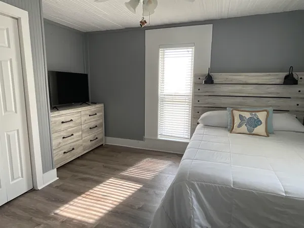 a bedroom with a bed and flat tv screen