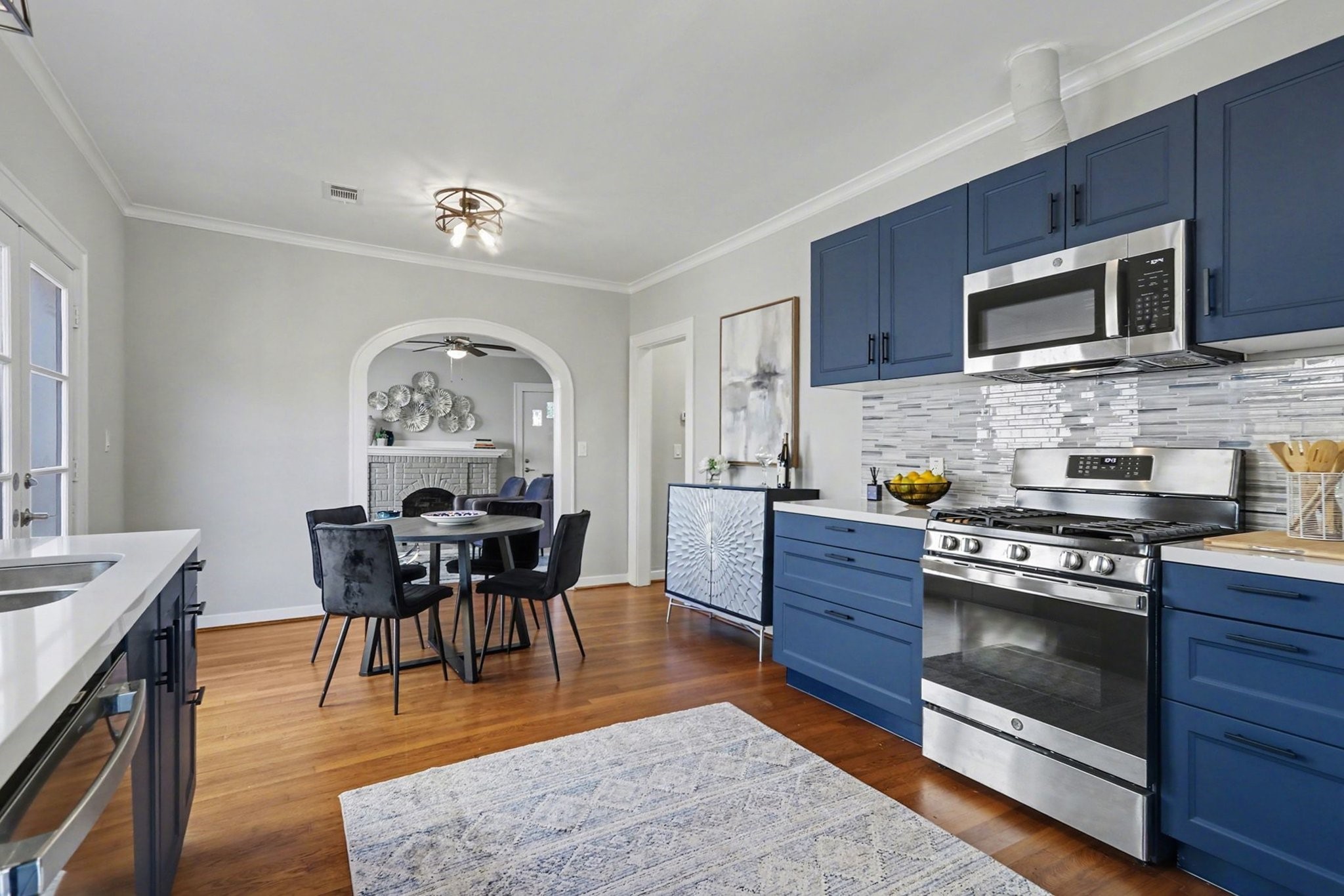 1901 Lexington Street Houston, TX 77098 - Photo 10 of 32 a kitchen with stainless steel appliances granite countertop a stove top oven a sink dishwasher a dining table and chairs with wooden floor