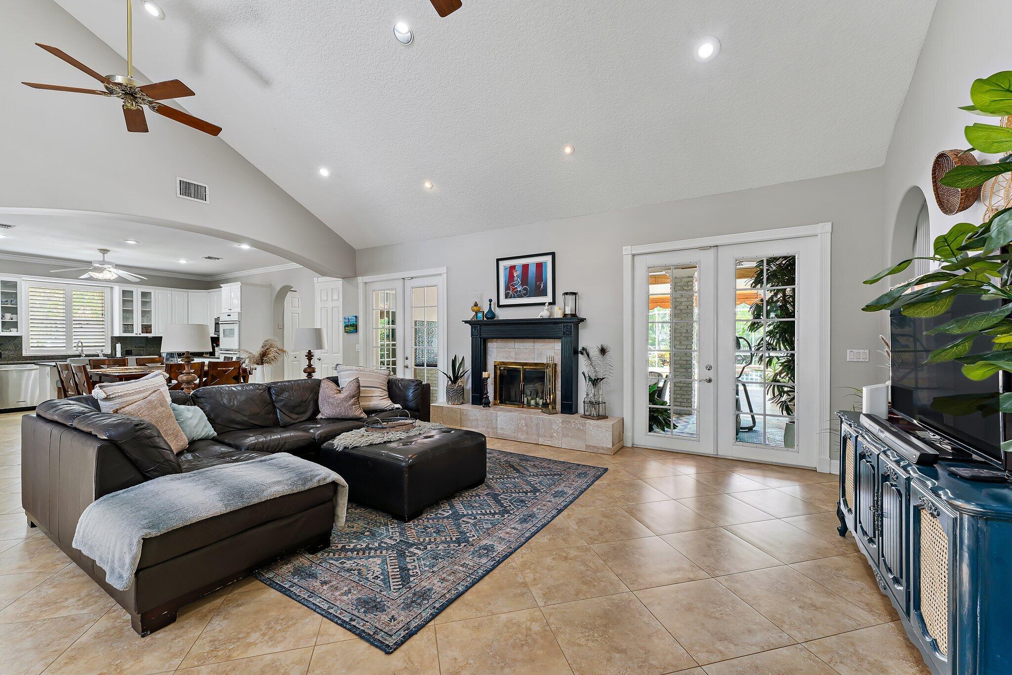 18263 River Oaks Drive Jupiter, FL 33458 - Photo 14 of 49 a living room with furniture a flat screen tv and a fireplace